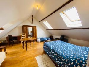 a bedroom with a bed and a table and a window at AmienSUD à 15 minutes du cœur de la ville in Saint-Sauflieu