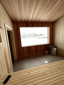 ein leeres Zimmer mit einem Fenster in einer Holzhütte in der Unterkunft Treeline Cabins in Cădăreşti