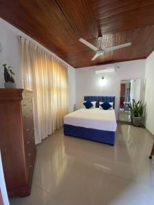 a bedroom with a blue bed and a wooden ceiling at New White House in Aluthgama
