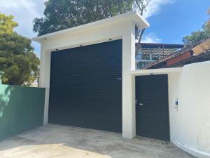 a garage with two doors on the side of a house at New White House in Aluthgama