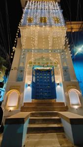 un edificio blanco con una puerta azul y escaleras en Jaswant Bhawan The Heritage Haveli, en Jodhpur