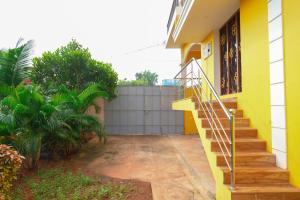 a yellow house with stairs in front of it at Prabas - Farm house in Puducherry
