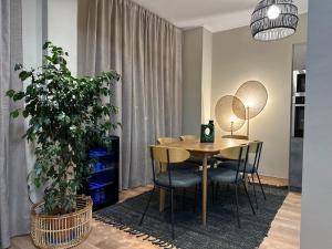 a dining room with a table and chairs and a plant at Acropolis Panorama Penthouse in Athens