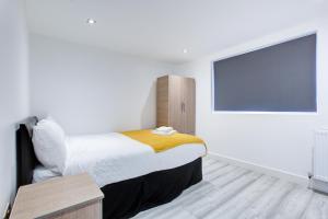a bedroom with a bed and a large screen at Charming 7 bedroom house sleeps up to 13 guests in Romford