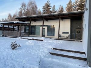 una casa con la neve davanti di Villa Harmony a Rovaniemi