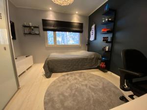una camera con un letto e una sedia e una finestra di Villa Harmony a Rovaniemi