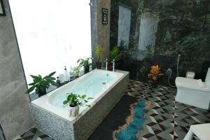 a bathroom with a tub with potted plants in it at Jewel of Jungle in Tāla +34 photos