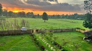 a field with a fence and a field with a sunset at Jewel Stay in Tāla