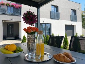 a table with a bowl of fruit and a bottle of orange juice at City Apartments in Liptovský Mikuláš