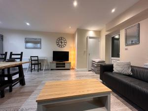 een woonkamer met een bank, een tafel en een televisie bij 5 Bed 5 Bath / Brick Lane Central London E1 in Londen