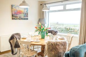 a dining room with a table and chairs and a window at Fleet View in Gatehouse of Fleet