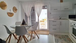 eine Küche mit einem Tisch und Stühlen sowie einem Fenster in der Unterkunft Esperanza 5 in Lebrija