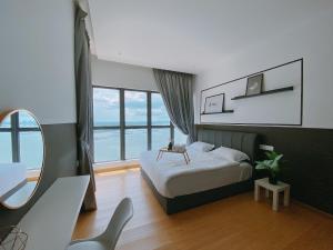 a bedroom with a bed and a large window at Seafront Country Garden Danga Bay by Lions Bay in Johor Bahru