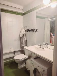 biała łazienka z toaletą i umywalką w obiekcie SilverSky Apartment w Warszawie