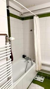 a white bath tub in a white tiled bathroom at SilverSky Apartment in Warsaw