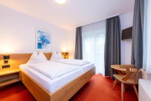 a bedroom with a large bed and a desk at Chalet Georg in Kaprun