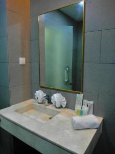 a bathroom counter with a sink and a mirror at Swiss Hotel Heritage Boutique Melaka in Melaka