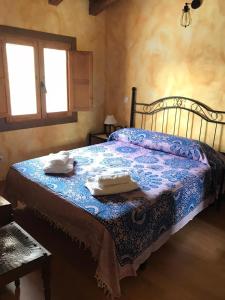 1 dormitorio con 1 cama con 2 toallas en El Canchal de Eladia, en Valdeverdeja