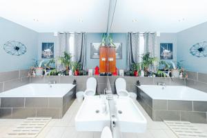 a bathroom with two sinks and two toilets at Master En - Suite Townhouse double with Garden & Hot Tub in London +76 photos