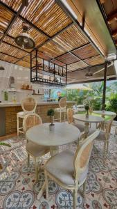 a dining room with tables and chairs and a kitchen at Matisia Hotel Boutique in Guaduas