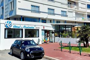ein kleines Auto, das vor einem Gebäude geparkt ist in der Unterkunft Hôtel La Croisette & Restaurant Bistrot Gantier in Royan