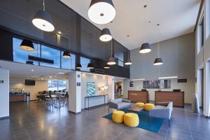 an office lobby with yellow chairs and tables at City Express by Marriott Tlalnepantla in Mexico City