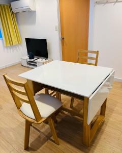 a white table with a chair and a television at home Shinjuku west101 in Tokyo