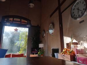 埃爾瓦斯的住宿－Albergue & Cafetería Vía de la Plata Hervás，墙上挂有时钟的房间和一张桌子