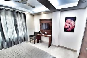 una camera con scrivania e sedia con un fiore sul muro di Airport Hotel Delhi Aerocity a Nuova Delhi