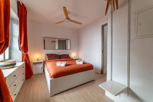 a bedroom with a red bed and a ceiling fan at Au cœur de l'Effervescence Terracotta - Une Nuit à Nîmes in Nîmes