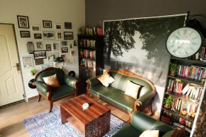 a living room with two chairs and a clock on the wall at Jewel Stay in Tāla