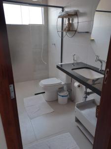 Baño blanco con aseo y lavamanos en Vila do Mar - Macapá, en Luís Correia