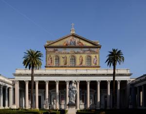 a building with a statue and palm trees in front at La Casa di Azzurra in Rome