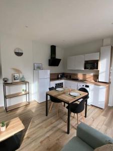 a living room with a table and a kitchen at Appartement hypercentre 100% équipé *Clim* in Brive-la-Gaillarde