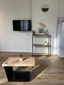 ein Wohnzimmer mit einem Tisch und einem TV in der Unterkunft Appartement hypercentre 100% équipé *Clim* in Brive-la-Gaillarde