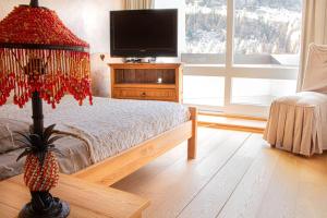 1 dormitorio con 1 cama con lámpara y TV en Le plus grand appartement, 150 M2, et la plus belle vue d'Isola 2000 Front de Neige en Isola 2000