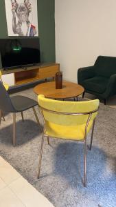 uma sala de estar com uma mesa e uma cadeira amarela em עלמה em Tel Aviv