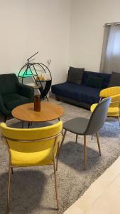 uma sala de estar com cadeiras amarelas e um sofá em עלמה em Tel Aviv