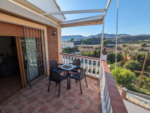 a patio with a table and chairs on a balcony at Chalet La Noria in Nerja