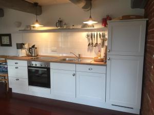 a kitchen with white cabinets and a sink at Hof Homfeld in Ditzum