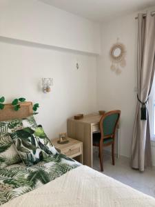 a bedroom with a bed and a desk with a chair at L'escale chic gare Saint Charles in Marseille