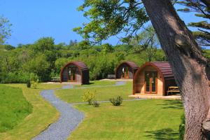 a couple of small wooden cabins in a park at Robin- Ensuite Glamping Pod in Truro