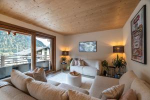 un soggiorno con divano e una grande finestra di La Ruinette - Modern 2 Bed, Close To The Lift a Le Châble