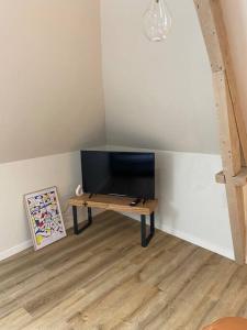 einen TV auf einem Tisch in einem Zimmer in der Unterkunft Appartement chaleureux - Clim réversible - Meublé A-Z in Brive-la-Gaillarde