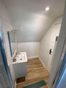 een witte badkamer met een wastafel en een spiegel bij Appartement chaleureux - Clim réversible - Meublé A-Z in Brive-la-Gaillarde