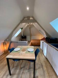 ein Zimmer mit einem Tisch und Stühlen im Dachgeschoss in der Unterkunft Appartement chaleureux - Clim réversible - Meublé A-Z in Brive-la-Gaillarde