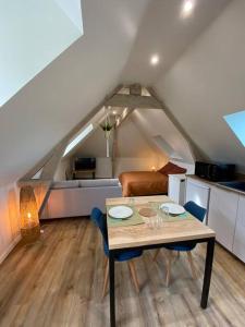 einen Esstisch und Stühle in einem Zimmer mit Dachgeschoss in der Unterkunft Appartement chaleureux - Clim réversible - Meublé A-Z in Brive-la-Gaillarde