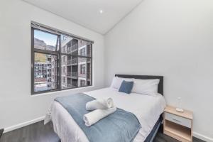 a bedroom with a large bed with towels on it at Mountain View Apartment at Woodstock Quarter in Cape Town