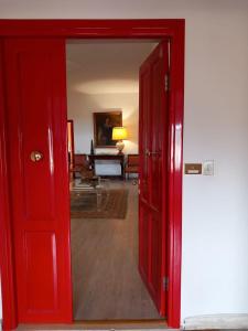 una puerta roja abierta a una habitación con sala de estar en San Gregorio, en Orte