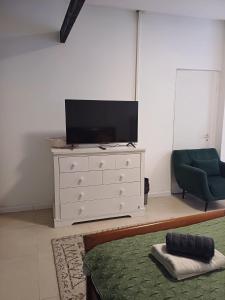 a living room with a tv and a white dresser at סטודיו איתמר in Tel Aviv